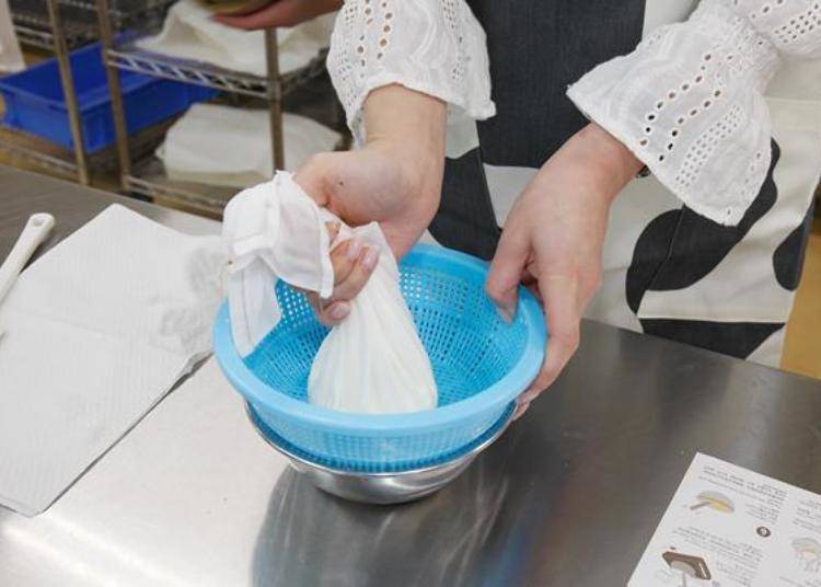 For approximately 5 minutes, lightly press the curds wrapped in cloth into the bowl.