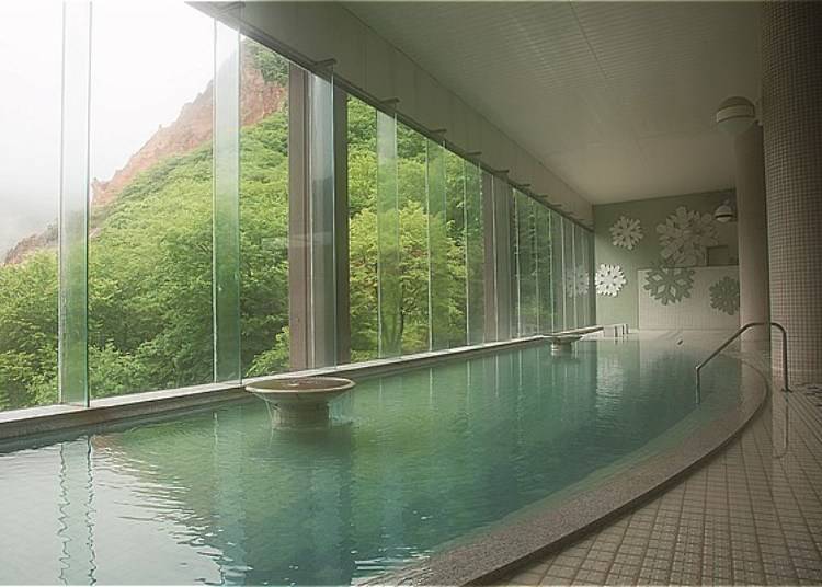 The indoor men’s Atsu no Yu (hot water bath) which overlooks Hell Valley. The view is so inviting that you may catch yourself standing up tall to take it all in. The mineral content in this bath can be enjoyed in both indoor and outdoor baths for both men and women (Photo: Dai-ichi Takimotokan)