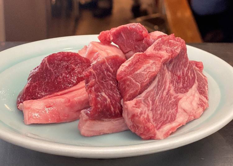 High-quality cuts of meat are served on a plate. These include a piece of mutton shoulder loin and two pieces of loin steak.