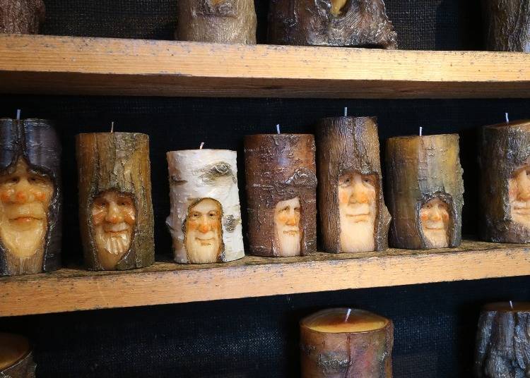 Images of forest sprites that appear to be carved in wood, but which are actually candles