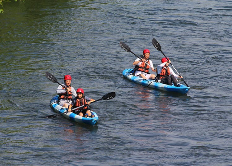 Kayaks leisurely going down stream surround by nature