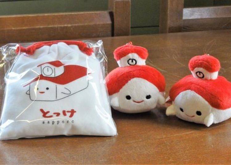Tokkei stuffed toy strap 463 yen each (right) and Tokkei Pouch of Butter Candies 378 per bag (left)