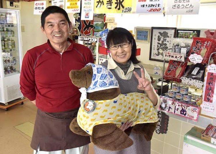 Shop owners Kazutoshi and Akiyo Ishikawa posing with a stuffed toy sea lion