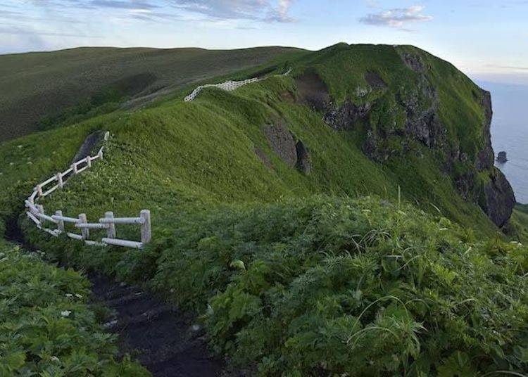 Steep cliffs and unusual rock formations overlook the sea on the right