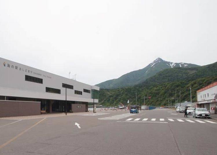 Mt. Rishiri, the landmark of the island, is in the background. The ferry terminal is on the left and a number of shops are lined up on the right. Sato Shokudo is the one at the far end.