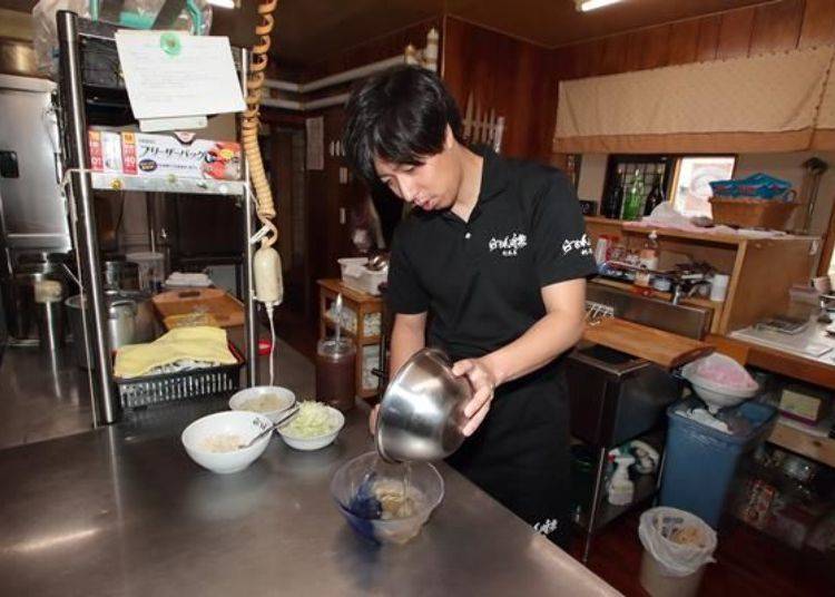 The soup is poured into a bowl, homemade salt sauce is added, and then slices of boiled chicken breast, green onions, and Tororo Kelp are added as topping.