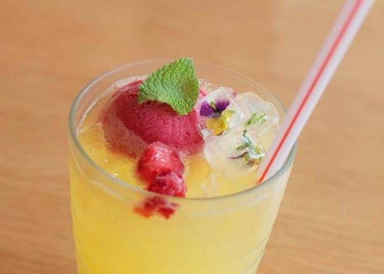 「綠丘茶房獨創的季節蘇打飲料」（含稅價格500日圓）。將冰塊製作成花卉冰塊，這飲品完全就是庭院風！