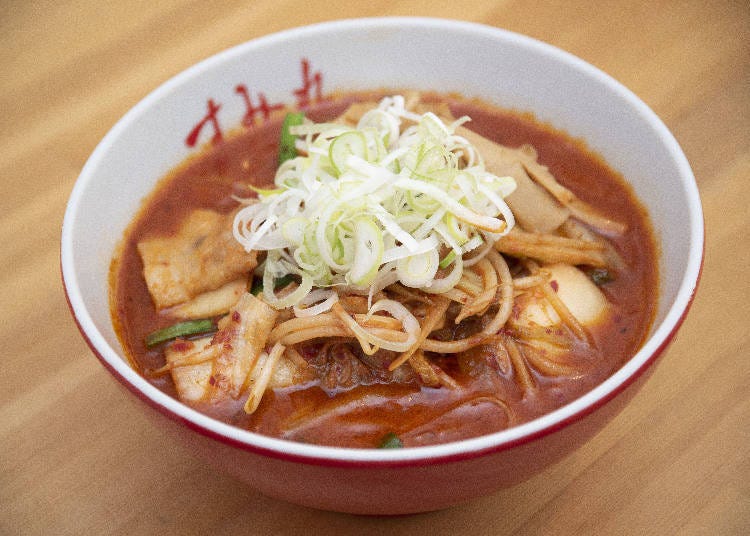 The thick soup is filled with many toppings such as onions, garlic chives, bean sprouts and thinly sliced pork belly.