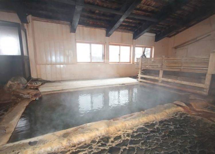 The indoor hot spring of the bathing area in the back side. The hot spring temperature is around 42°C and a bit hot. Behind the fence to the back right are two bathtubs.