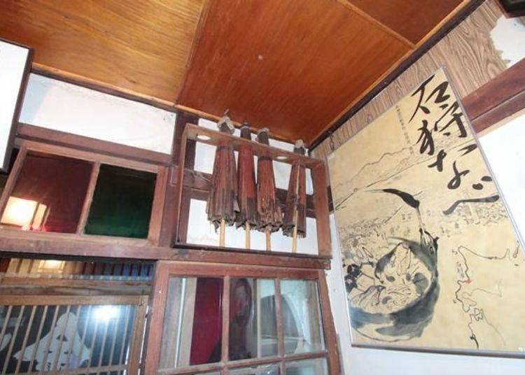 玄關裝飾著年代久遠的油紙傘與畫報。