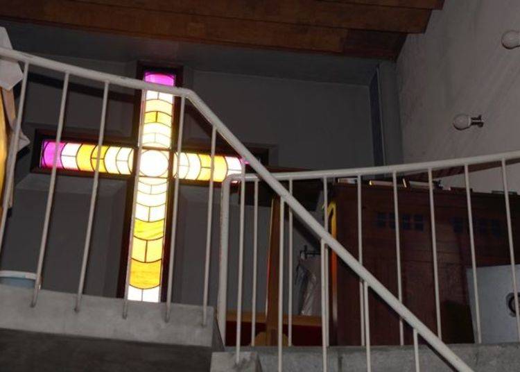 ▲從教堂內所看到刻在外面白牆上的十字架，是設計成璀璨的彩繪玻璃十字架。