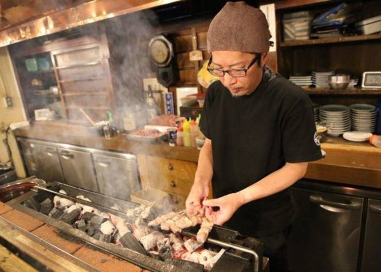 ▲Manager Hideaki Kato. Slowly grilling meat it over the charcoal fire.