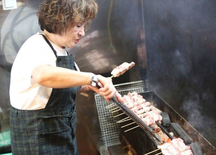 ▲ Ms.Yoshida preparing charcoal and grilling meat.