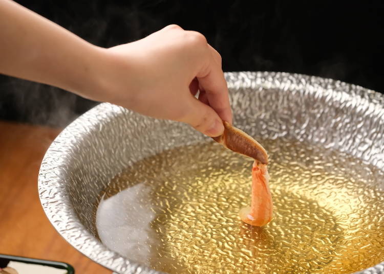 Dip the crab leg into the pot. Hold it firmly while slowly swishing it left and right.