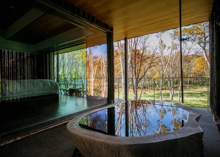 Soak in the hot springs while gazing at the autumn leaves from your own private space