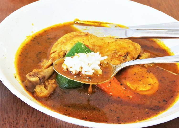 ▲Soup curry is generally eaten as per this image - dip and soak the rice in the soup.