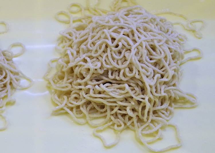 The pre-cooked noodles are thin and curly.