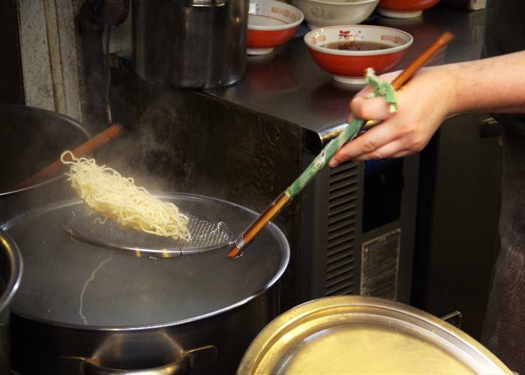 Mid noodle flip at Kawamura. The thin noodles boil almost immediately, so they require skill to be quickly drained and served.