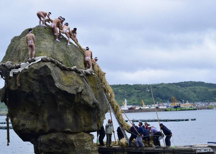 At the Esashi Kamomejima Festival, held on the first Saturday and Sunday of July every year, locals replace the old shimenawa on Heishi Rock with a new one. (Photo courtesy of Esashi Tourism Convention Association)
