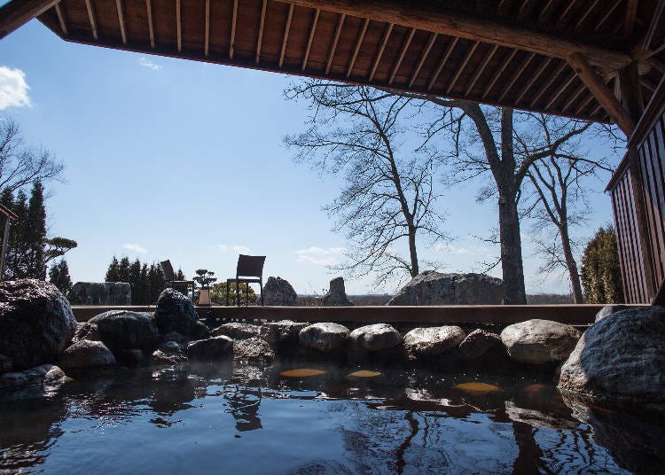 The moor onsen open-air bath has a garden with rocks and grand views of the Tokachi River surroundings (Photo: Kangetsuen)