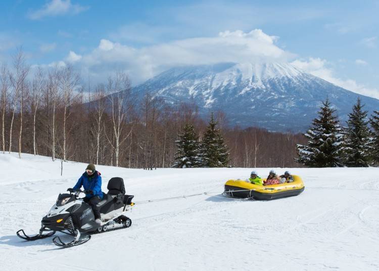 ▲用雪上摩托車拖曳雪上泛舟的橡皮廷，奔馳在雪地上（照片提供：Hilton Niseko Village