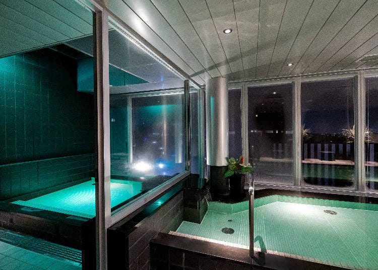 The large bath, with a night view. Guests can use it as many times as they like during their stay.
