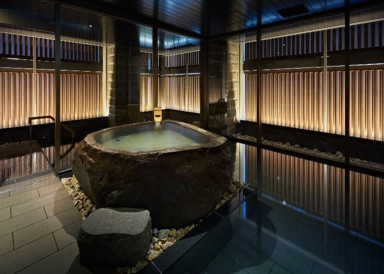 The large bath features subdued lighting and a relaxed atmosphere.