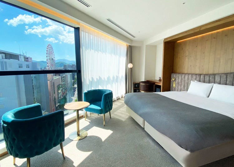 Deluxe King room offers a panoramic view of the Sapporo cityscape from the room-length window.