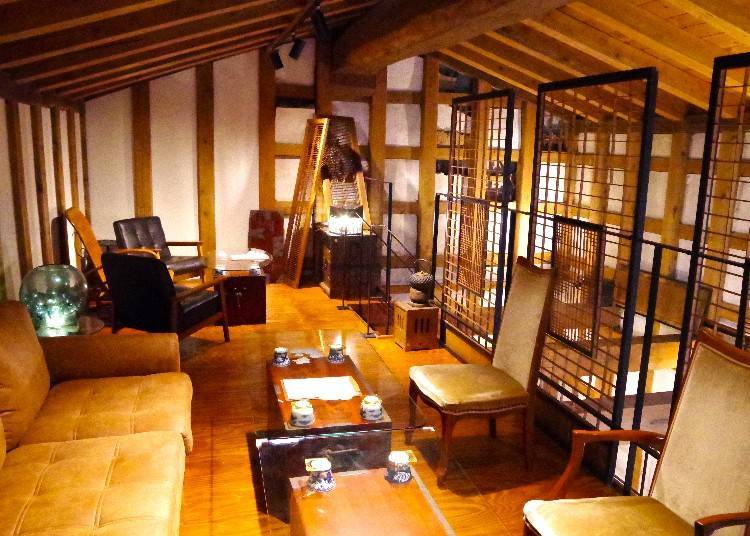 The two-story building features the kitchen and counter seating on the first floor, and sofa and chairs on the second floor, with a partial atrium.