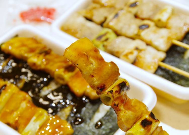 Yakitori bento with sauce, and pork and green onion skewers.