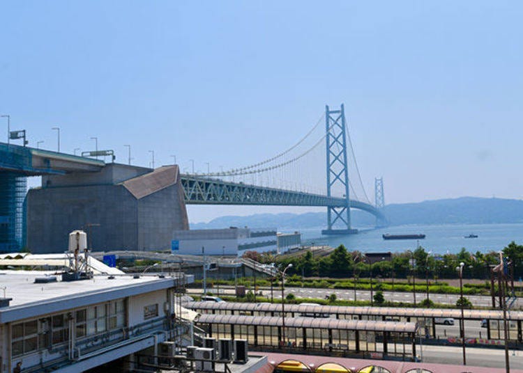 ▲從神戶看向明石海峽大橋時最令人印象深刻的就是兩座聳立的橋塔。正前方是最靠近明石海峽大橋的JR舞子車站，橋另一端所連接的島嶼就是淡路島