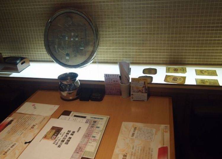 ▲On each table there are barrel lids with pictures or labels from old sake bottles, giving you a sense of the history of this brewery.