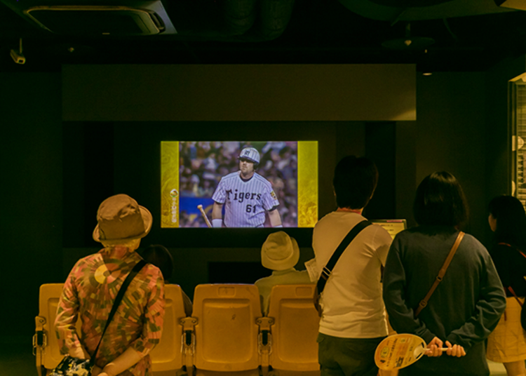 ▲Many visitors pause to watch memorable video clips