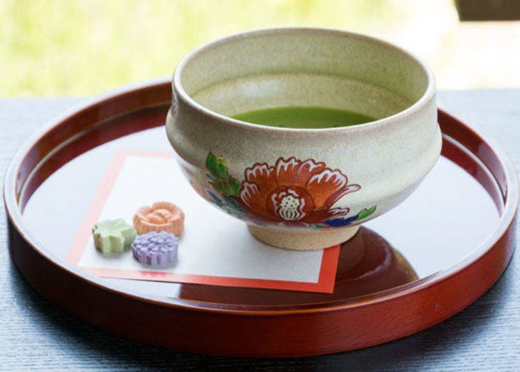 ▲抹茶（500日元）。这绘制了牡丹的抹茶碗是奈良代表性的陶器－赤肤烧。干果子是寺院周边的和果子店特别订做出给长谷寺专用的。