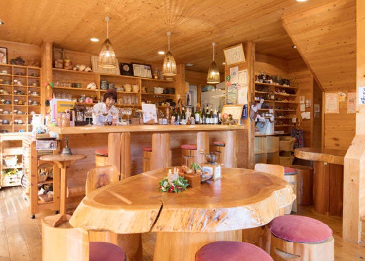 ▲The café has a warm and cozy wood interior. That is the owner, Ms. Fukumi Nishikawa, working behind the counter.