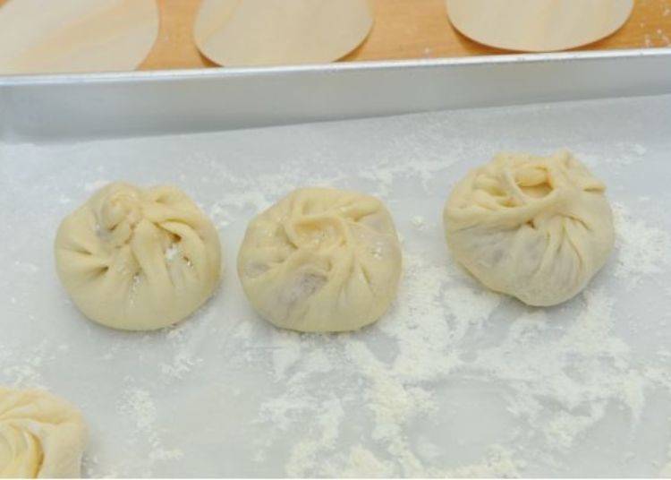 ▲You can make three pork buns in this workshop. The first one I made on the right is distorted; the second one I made, in the middle, looked better. As for the third one I made, on the left, I had stretched the dough too much so it also was less than perfect.