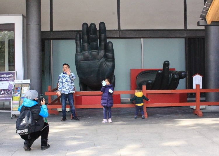 A replica of the giant Buddha's hand displayed beside the entrance