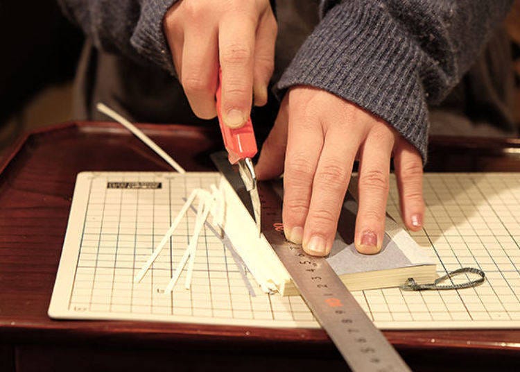 Ms. Muramatsu cuts sheets of paper one by one with a cutter