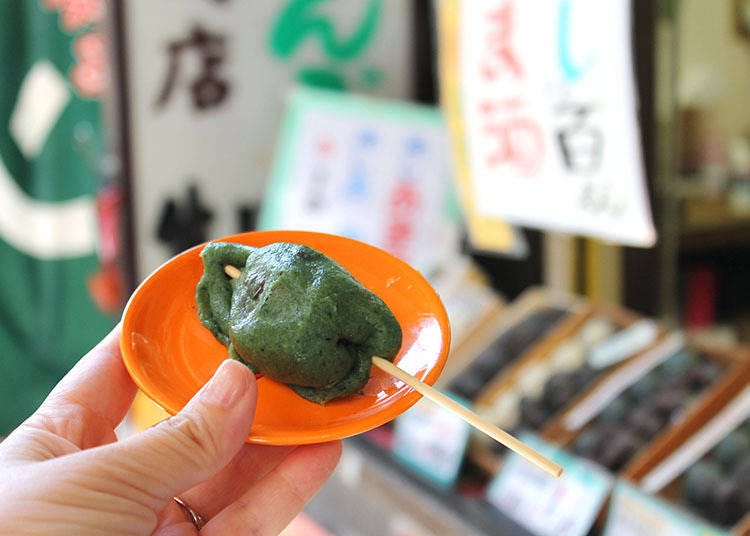 照片為鄰近石切先生的點心舖子所販賣的「艾草團子（原味）」，一串100日圓（含稅）。另外還有黃豆粉及紅豆餡口味的「烤艾草團子（加料）」，一串150日圓（含稅）