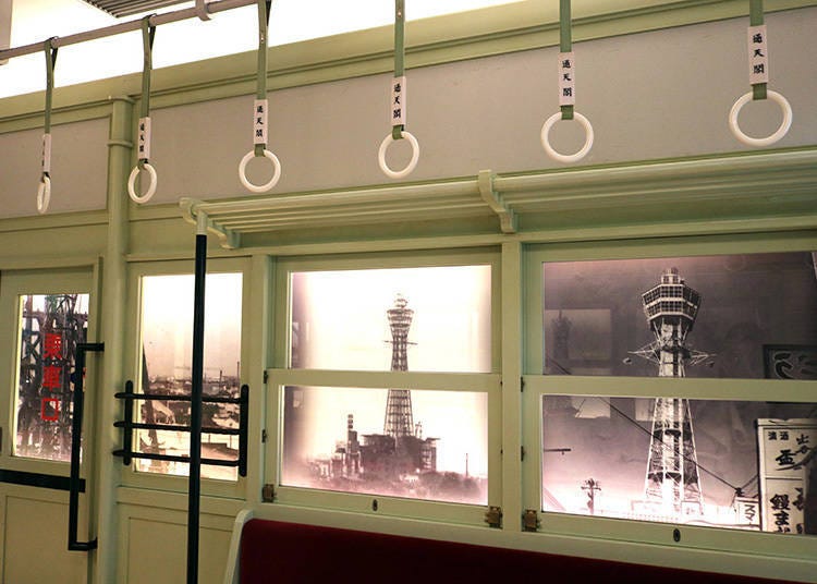 A reproduction of the interior of the nearby Hankai Tramway. The kanji for Tsutenkaku is written on the straps. (2F)