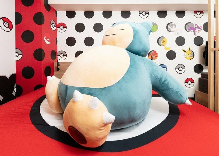 Two of the most exciting features of this Pokemon hotel room are, without a doubt, the gigantic Snorlax plushie, and the Pokeball-themed bed!