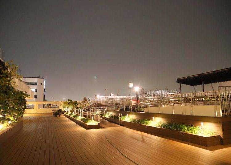 A romantic view of the runway at night from an illuminated deck