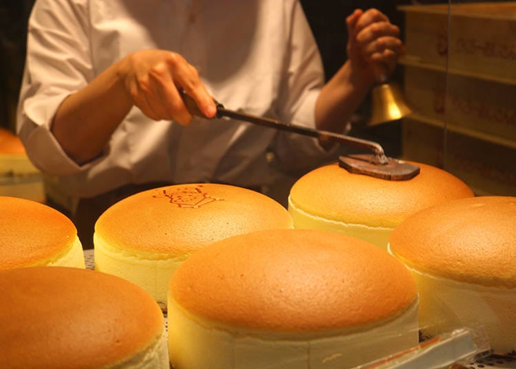 The chef rings the bell while branding the cheesecake