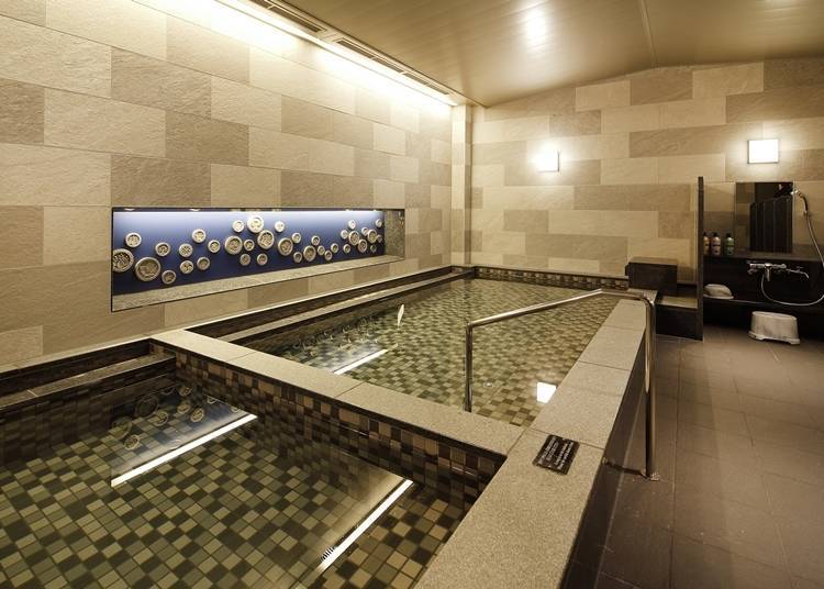 Inside the bathing facility, Trinite, the men’s bath is equipped with a dry sauna, whereas the women’s bath features a mist sauna.