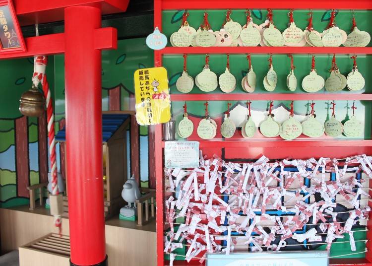 たわわ神社の隣には、願いを込めた「たわわちゃん絵馬」と結びつけられた「たわみくじ」