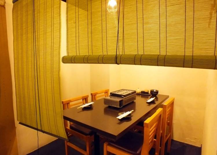 A semi-private room partitioned off with bamboo blinds