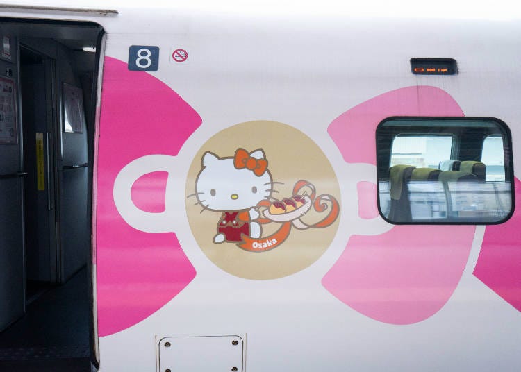 A photo of Osaka Prefecture Hello Kitty holding some Takoyaki-octopus balls.