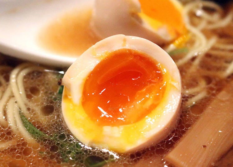 The marinated egg is added whole, with the yolk inside spilling into the soup when cut with chopsticks.