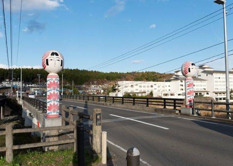 ▲ Large kokeshi dolls stand at each end of the bridge. See if you can also spot the small kokeshi dolls on the bridge.