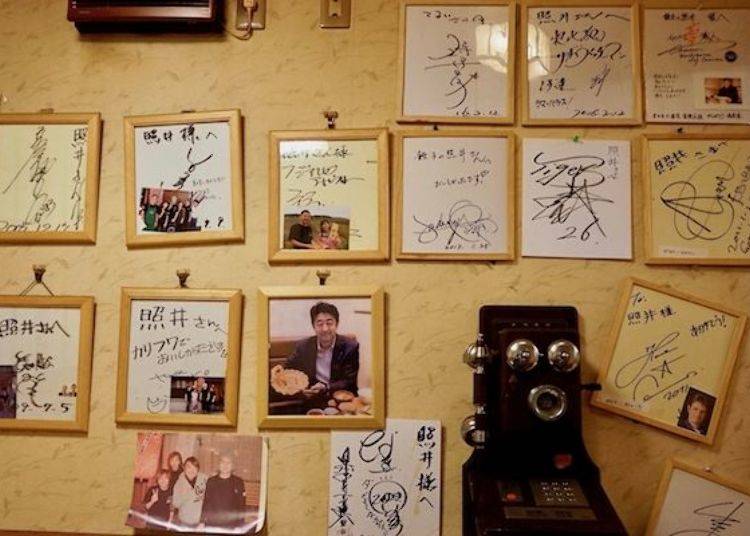 ▲ Many autograph cards and photographs of famous visitors line the walls.